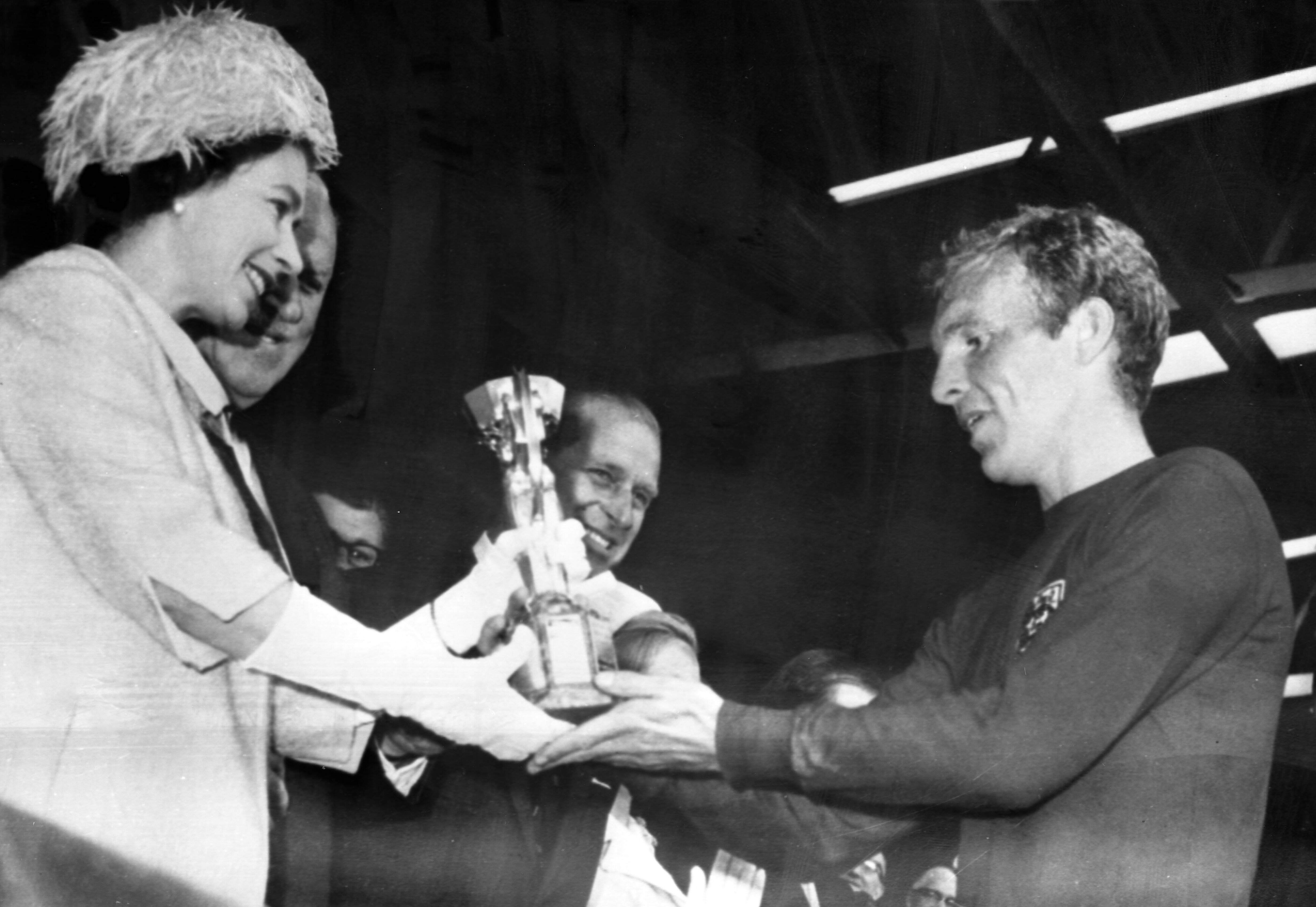 IMAGO / TopFoto | Elizabeth II is pictured presenting the Jules Rimet World Cup Trophy to England s Captain Bobby Moore, after England defeated West Germany in the final of the World Cup Tournament at Wembley Stadium today. 