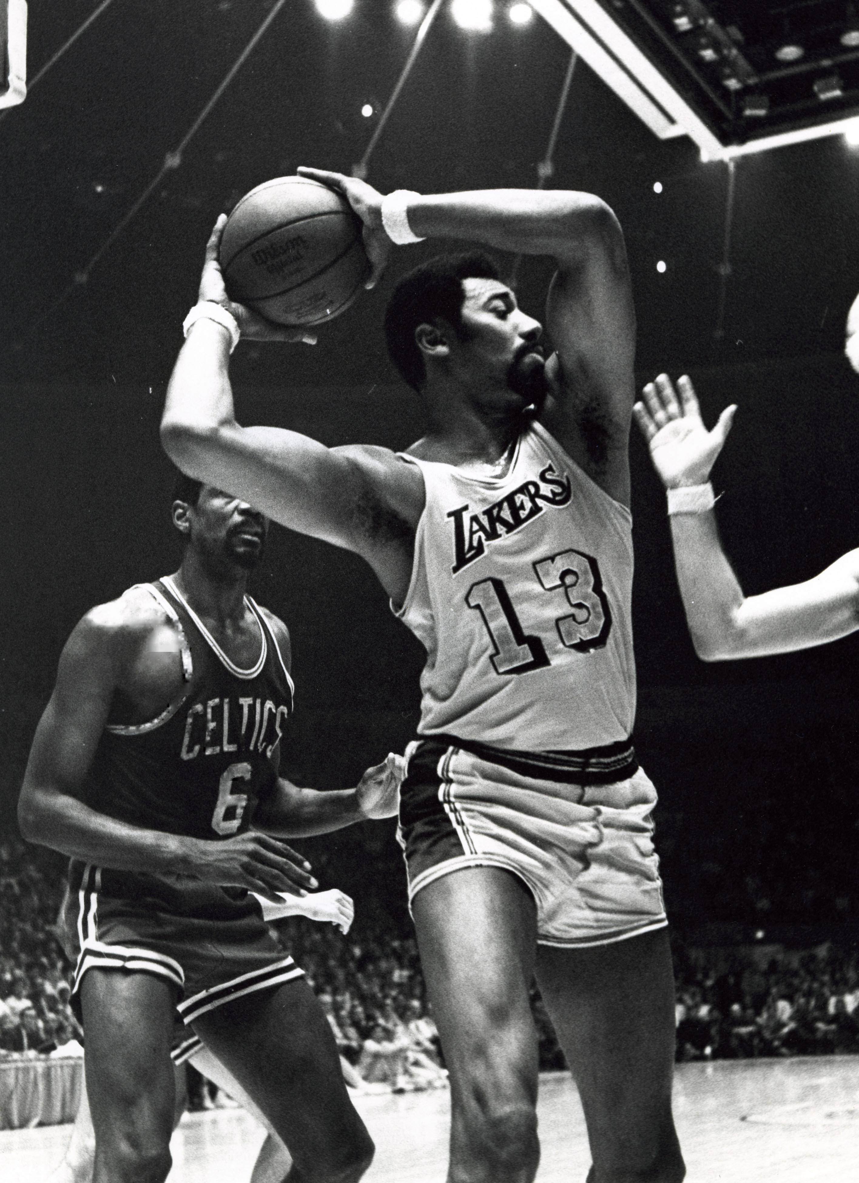 Lakers center Wilt Chamberlain (13) battles for a rebound in front of Boston Celtics center Bill Russell (6)