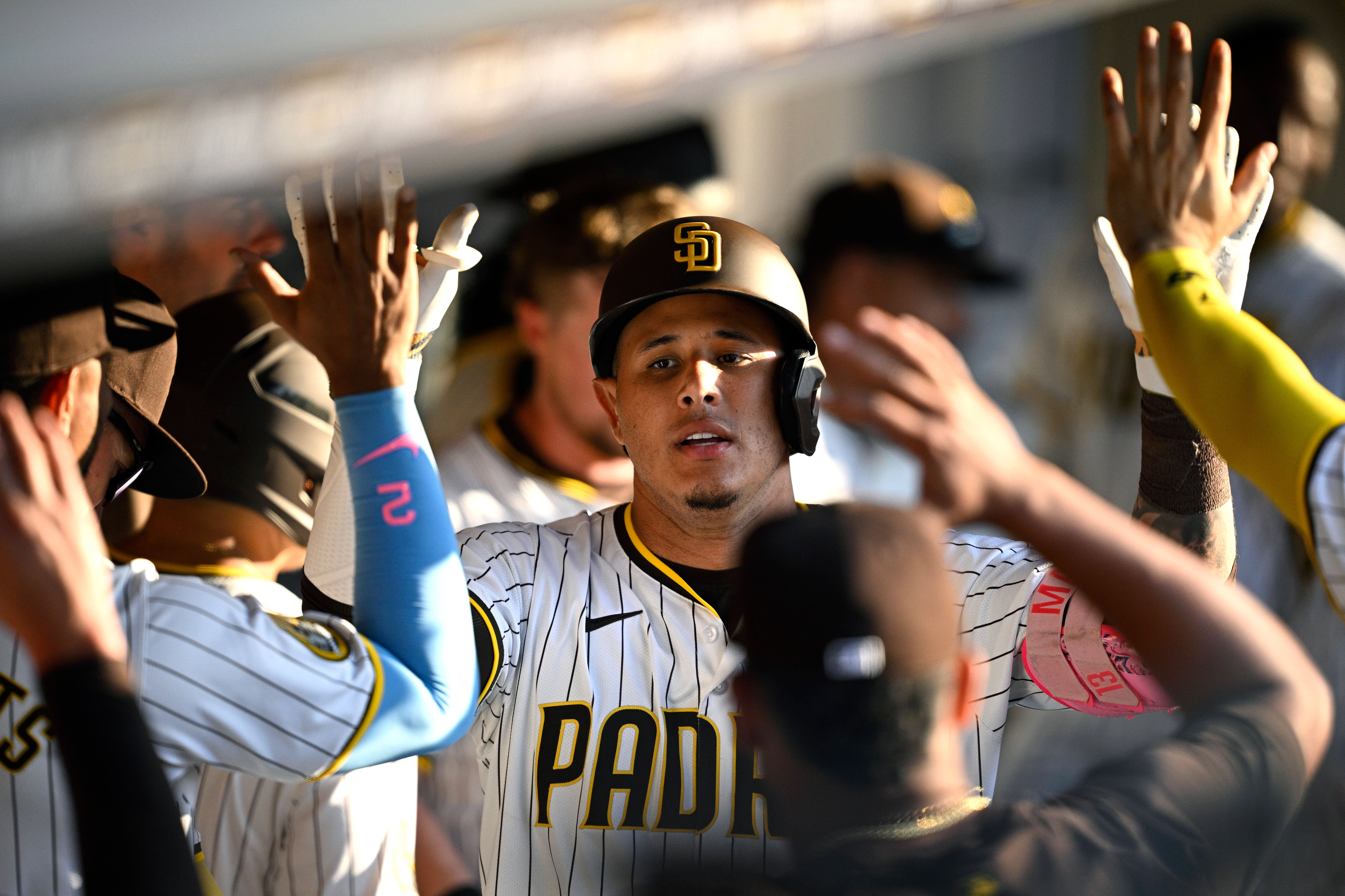  San Diego Padres designated hitter Manny Machado (13) is congratulated in the dugout after hitting a home run.
