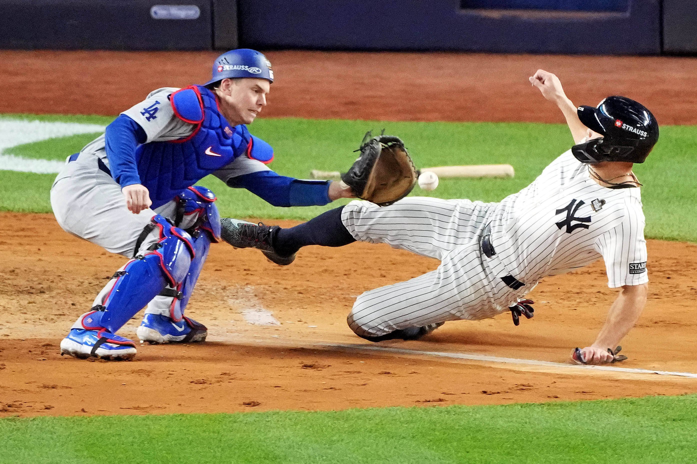 Los Angeles Dodgers catcher Will Smith (16) tags out New York Yankees designated hitter Giancarlo Stanton (27) at home plate.